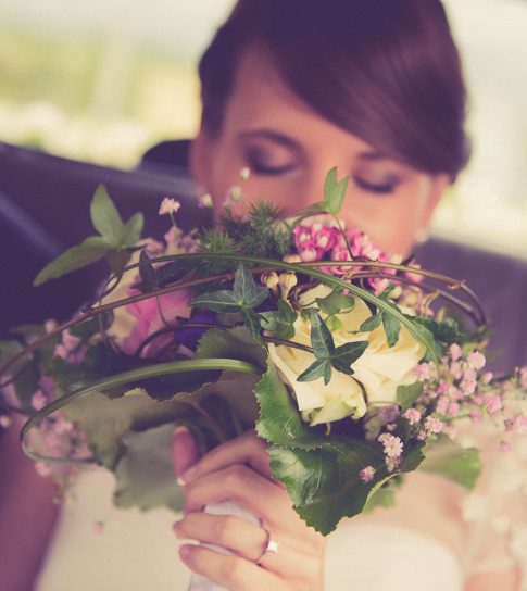 Brautstrauß und Braut im Hochzeitsauto